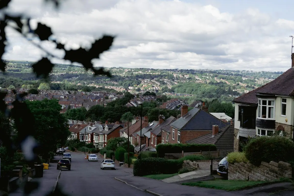 Suburban street of semi-detached and terraced houses running downhill