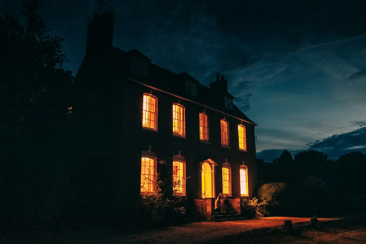 Brick house at dusk with warm light in every window