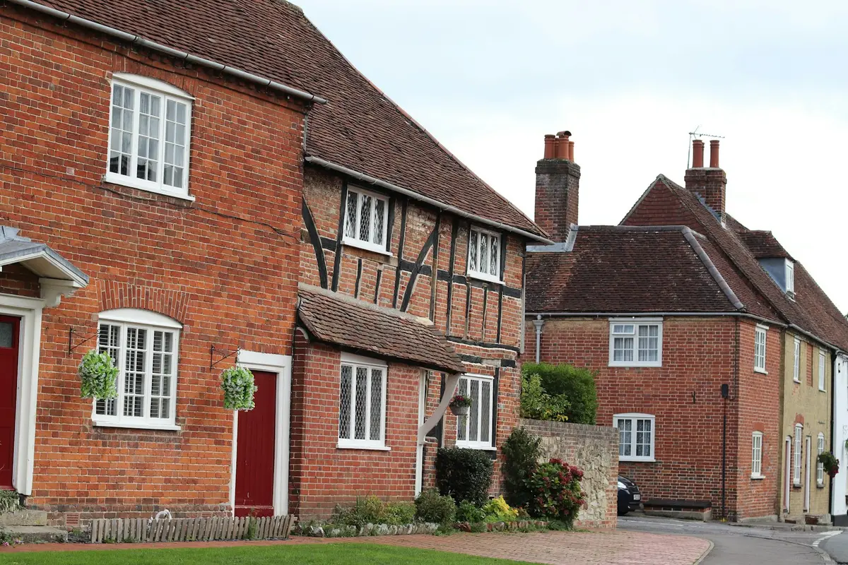 Village row of brick and timber-framed cottages with white casement windows