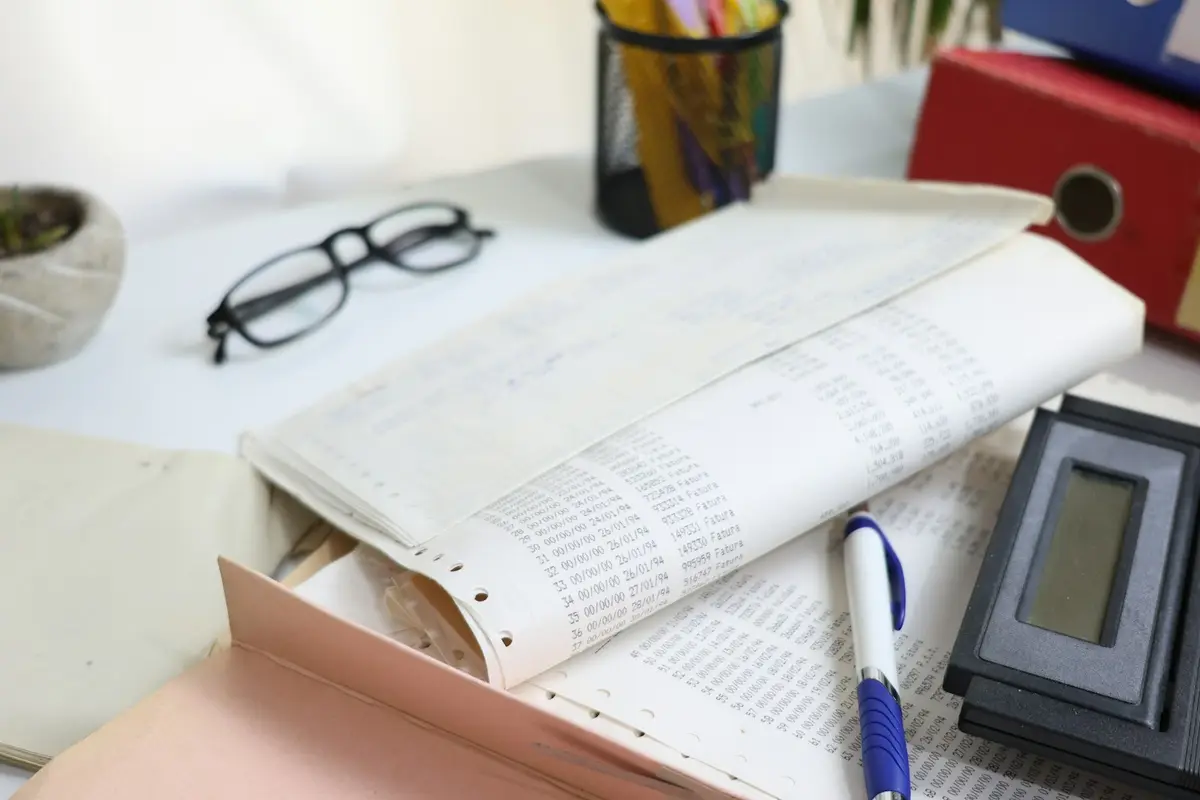 Paperwork, a pen and a calculator on a desk