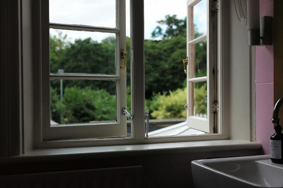 White side-hung casement windows swung fully open, seen from inside