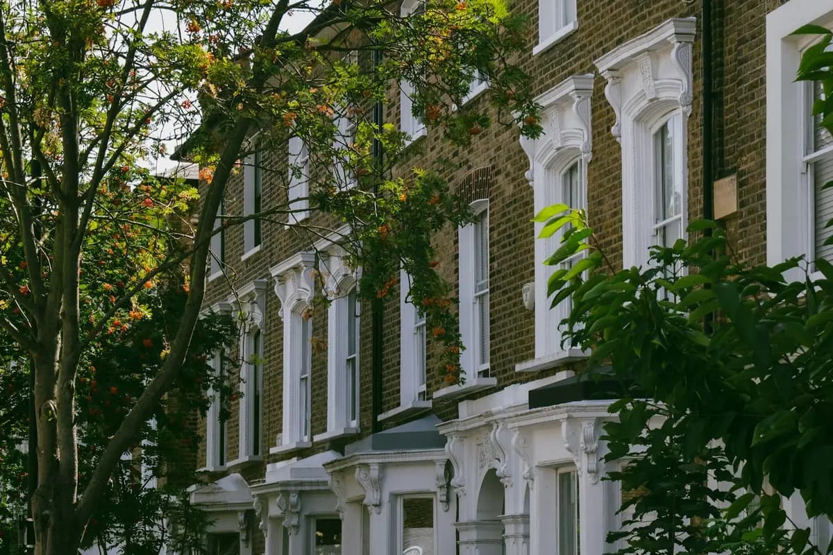 Victorian stucco terrace with bay and sash windows on a tree-lined London street